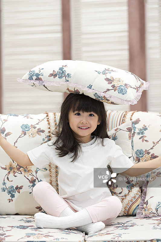 快乐的小女孩坐在沙发上图片素材