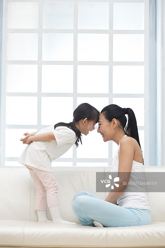 快乐的母女俩在沙发上玩耍图片素材