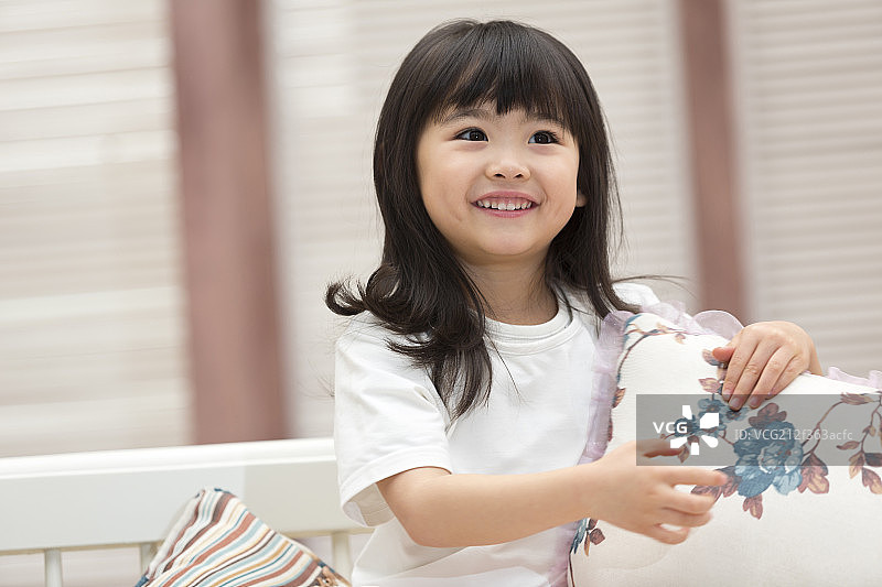 快乐的小女孩坐在沙发上图片素材