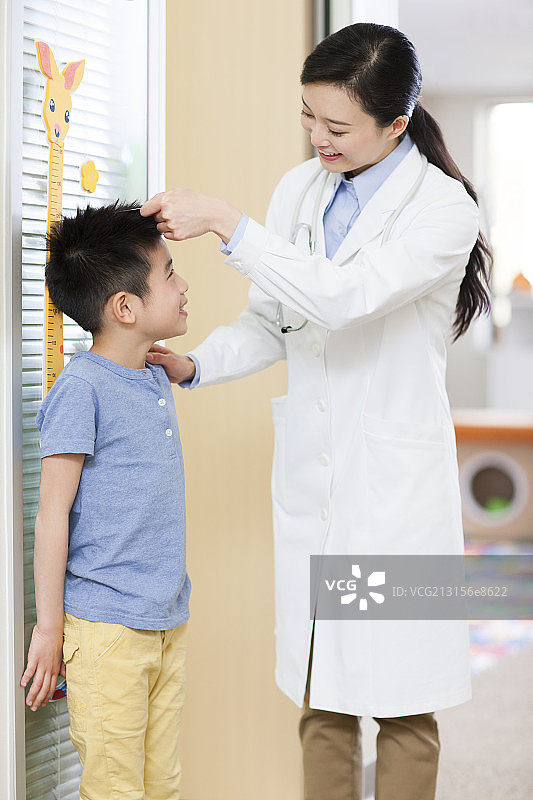 医生给小男孩量身高图片素材