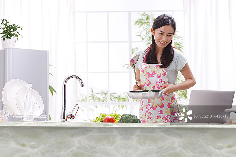 年轻女人在厨房做饭图片素材