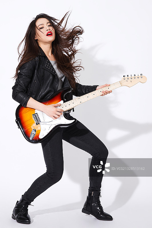时尚的青年女人在弹吉他图片素材