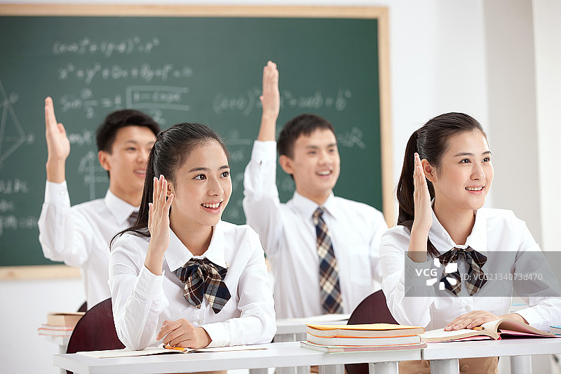 中学生在教室的课堂上举手图片素材