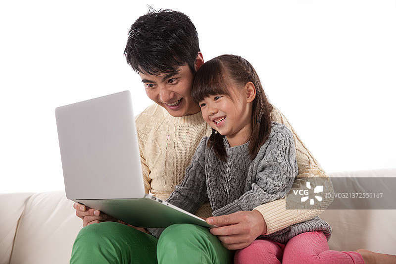 父亲和女儿坐在沙发上使用掌上电脑图片素材