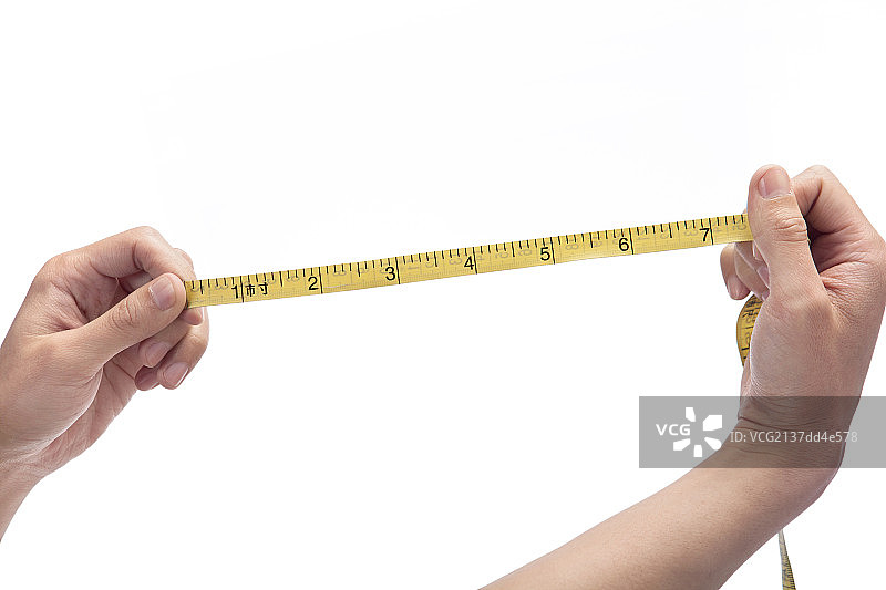 白色背景下拿尺子的手图片素材
