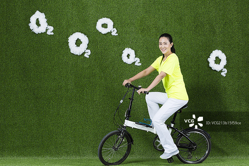 草地创意女青年骑自行车图片素材