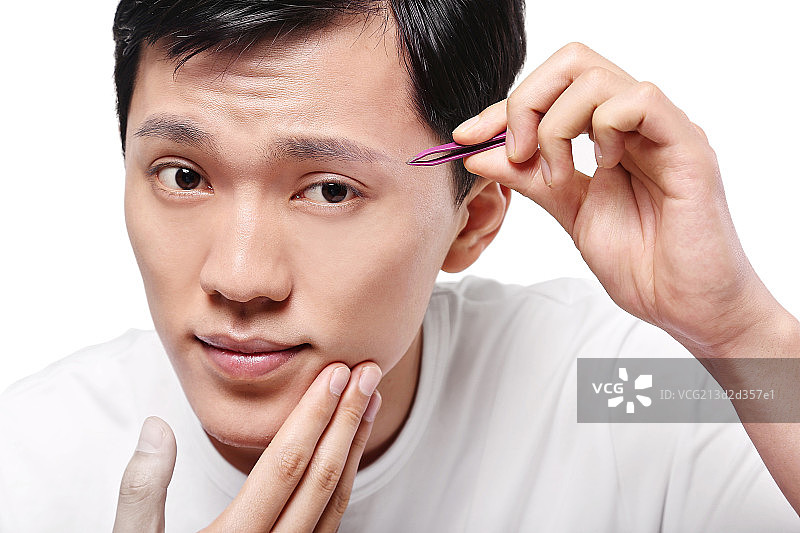 手拿镊子的清爽男士图片素材