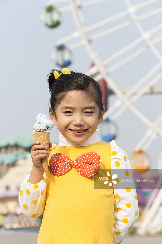 小女孩在游乐园吃冰淇淋图片素材