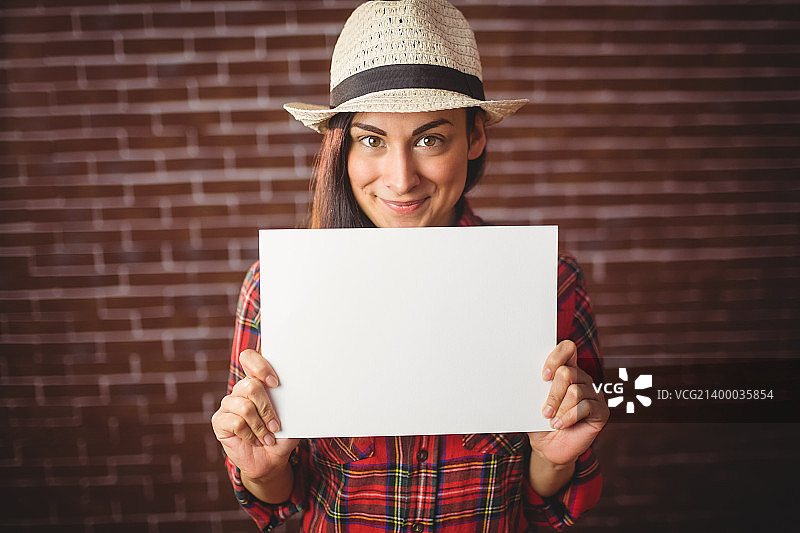 在红色砖墙背景上展示白卡的潮流人士图片素材