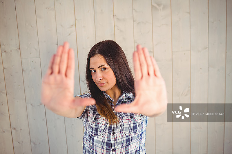 时尚年轻人木板背景前举双手图片素材