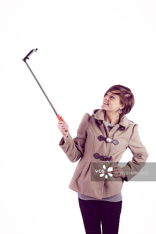 用自拍杆自拍的迷人女性图片素材