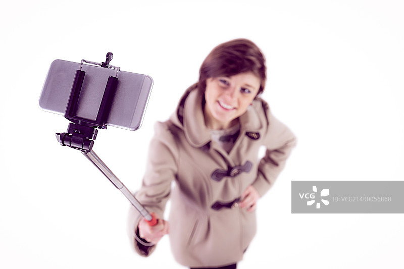 用自拍杆自拍的迷人女性图片素材