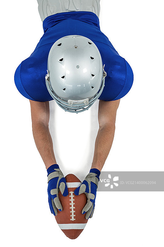 俯视角度拍摄的橄榄球运动员伸手接球，背景为白色图片素材