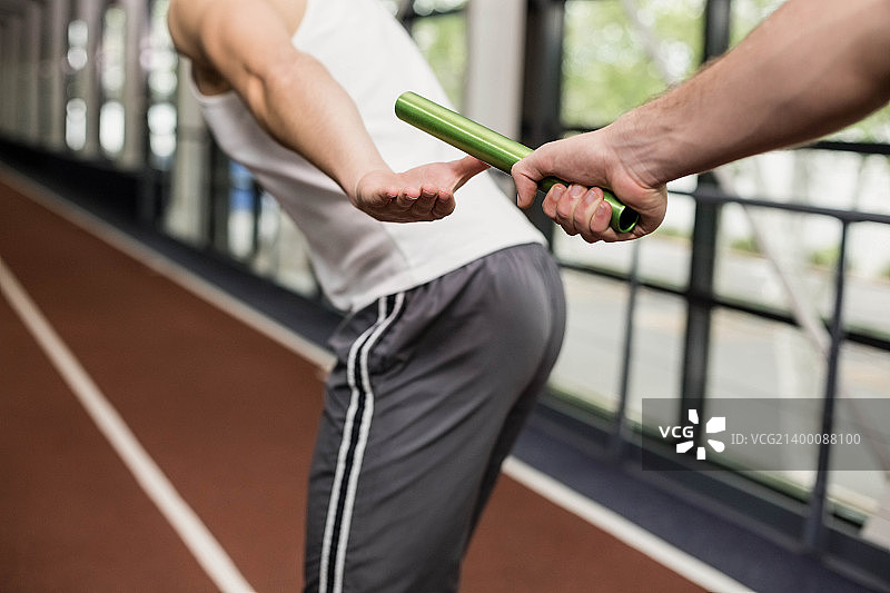 男人将接力棒传递给同伴图片素材
