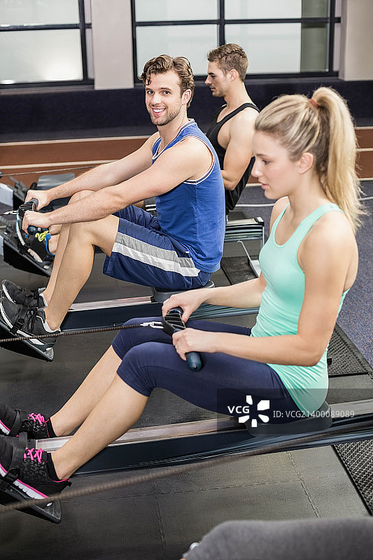 在划船机上锻炼的健壮人群图片素材