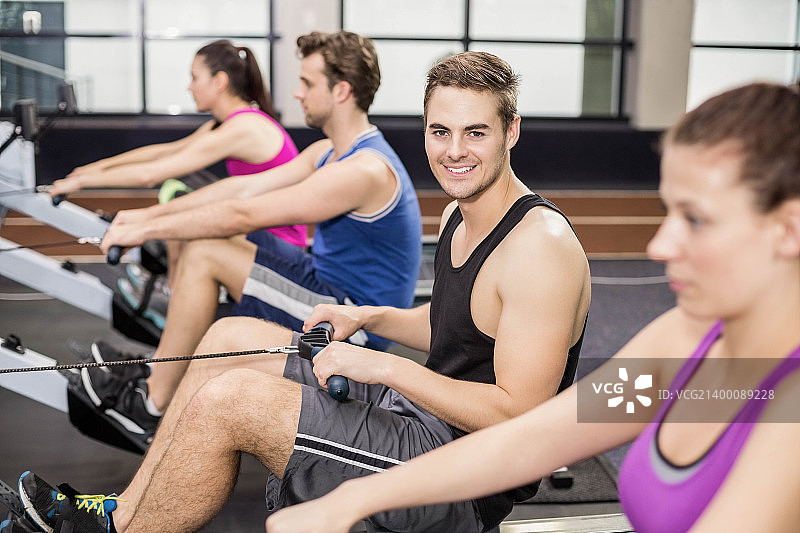 在划船机上锻炼的健壮人群图片素材