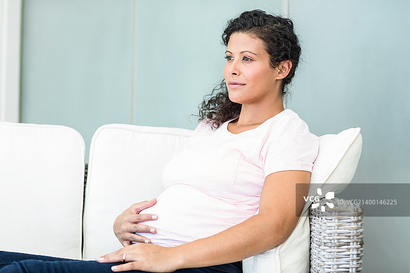 快乐的孕妇在沙发上图片素材