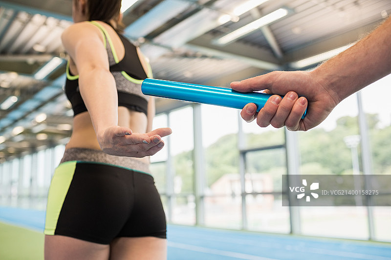 男人将接力棒传递给伙伴图片素材