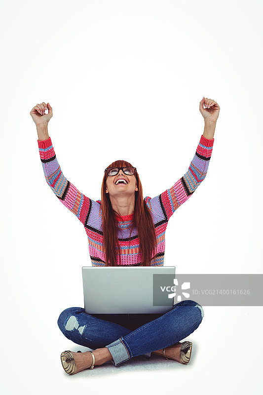 微笑的雅痞女子正在使用笔记本电脑图片素材