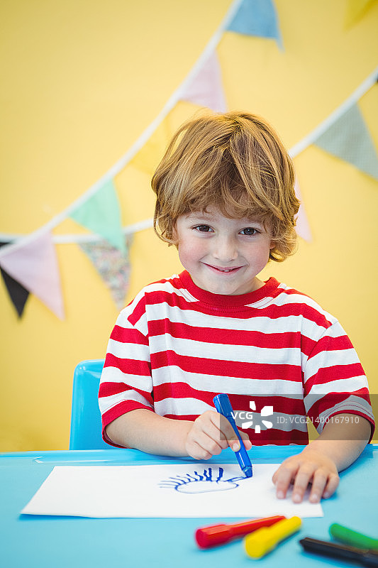 微笑的男孩在纸上着色图片素材