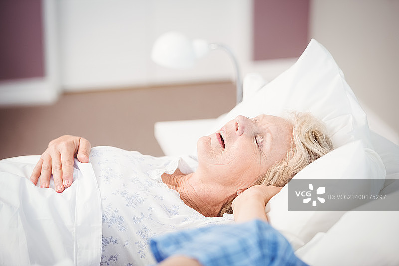 在丈夫旁边打鼾的年长女人图片素材