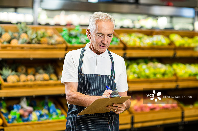 中年工人在写字板上书写图片素材