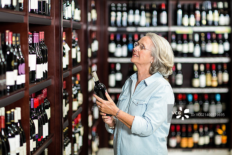 年长的女人在挑选葡萄酒图片素材