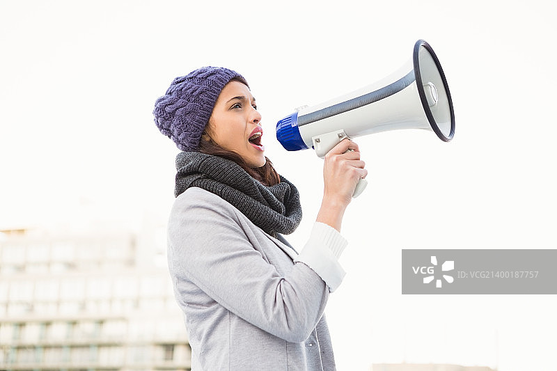 微笑的女人用扩音器喊叫图片素材
