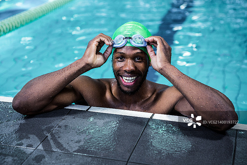 游泳池中微笑的健壮男子图片素材