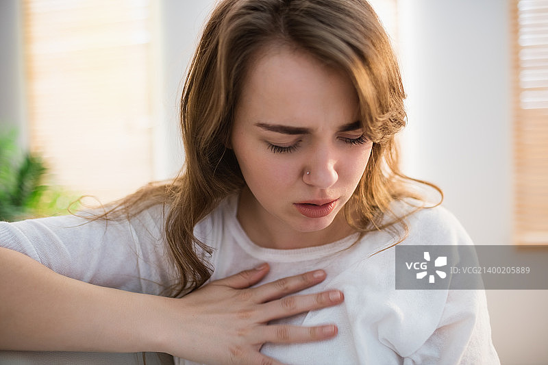 感到胸部不适的漂亮女人图片素材