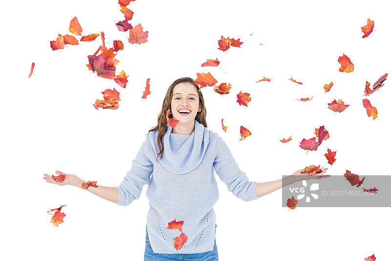 快乐的女人在w上扔树叶图片素材