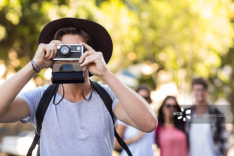 时髦的男人用宝丽来拍照图片素材