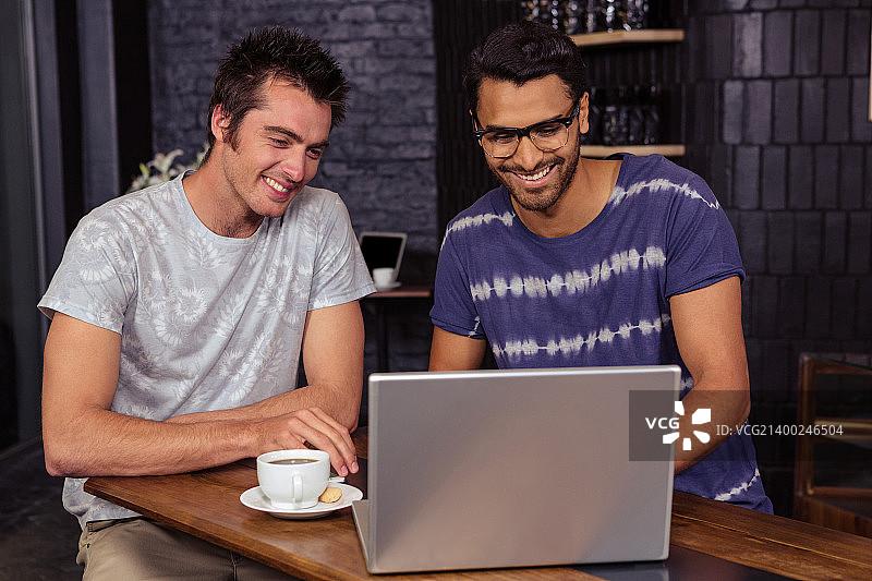 朋友们在咖啡馆使用笔记本电脑图片素材
