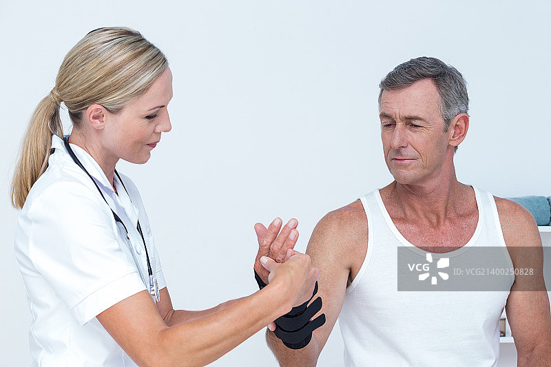 医生在诊所检查男人的手腕图片素材