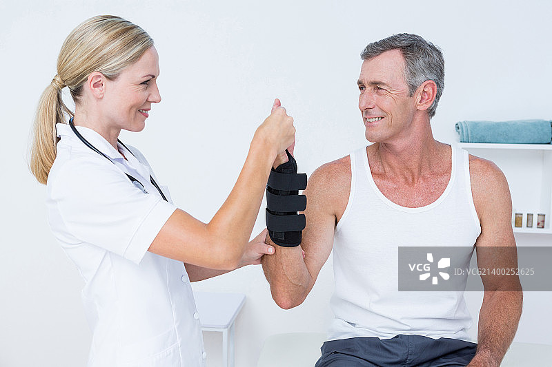医生在诊所检查男人的手腕图片素材
