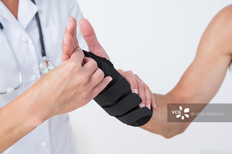 医生在诊所检查男人的手腕图片素材