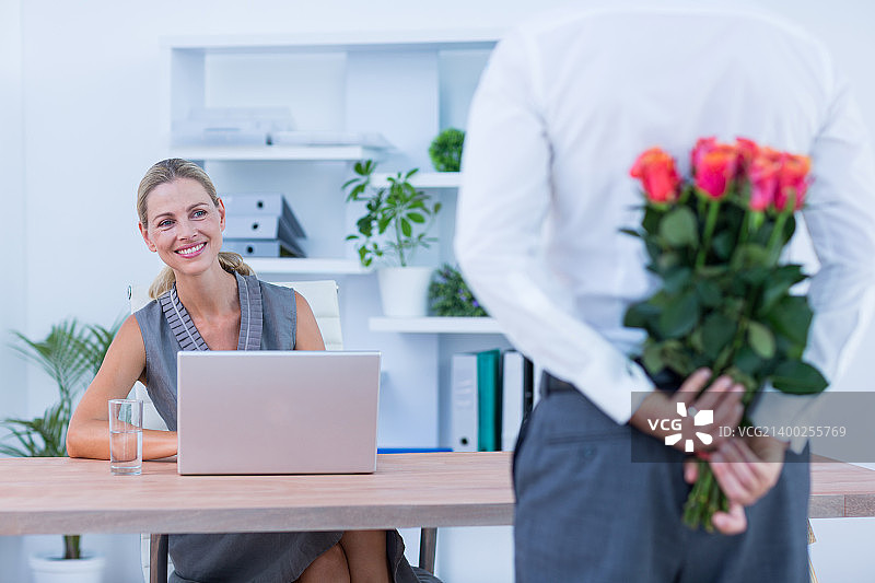 男商人藏花送给办公室同事图片素材