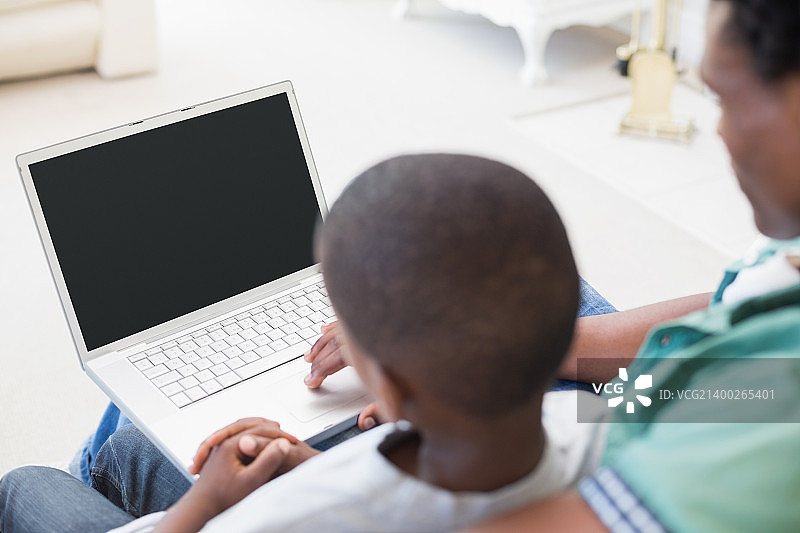 父子在家客厅沙发上用电脑图片素材