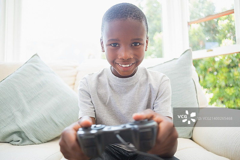 小男孩在家里的客厅玩电子游戏图片素材