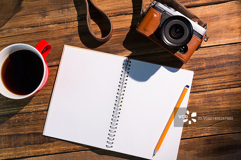 咖啡杯、相机和笔记本上的钢笔图片素材