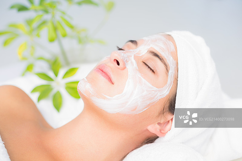 在水疗中心脸上涂抹白色面霜的女子图片素材