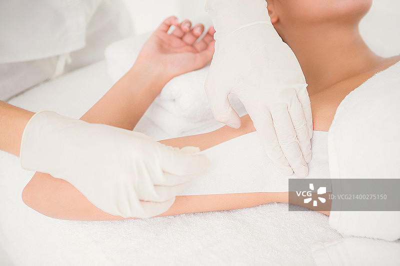 理疗师在水疗中心为女子腋下脱毛的身体中部照片图片素材