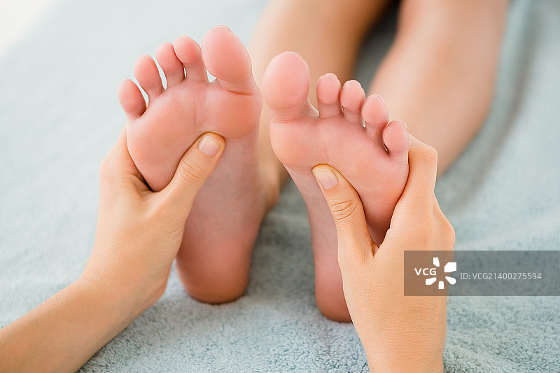 年轻女子在水疗中心接受足部按摩特写图片素材