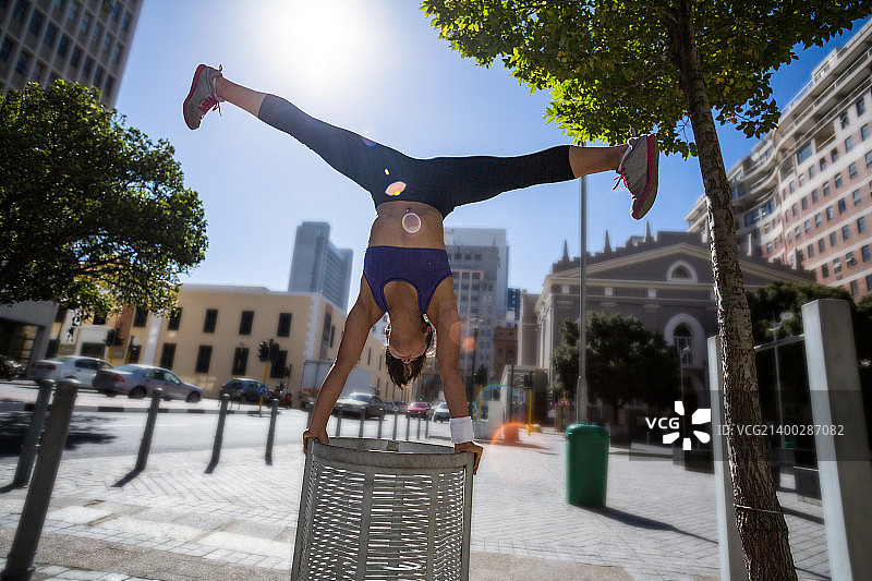 运动女性在城市中表演倒立和劈叉图片素材