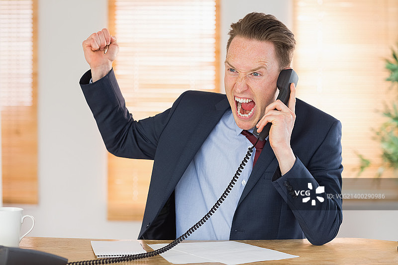 在办公室里对着电话发火的商人图片素材