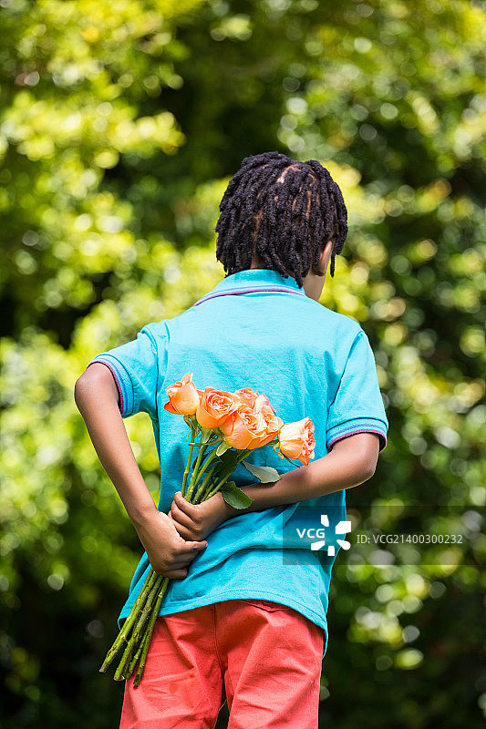 儿童藏着花束的背影图片素材
