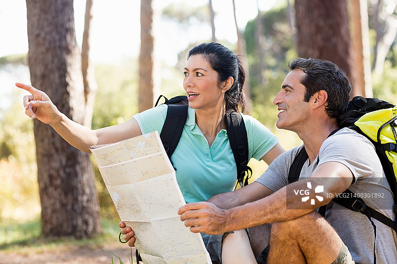 情侣坐着并拿着地图图片素材