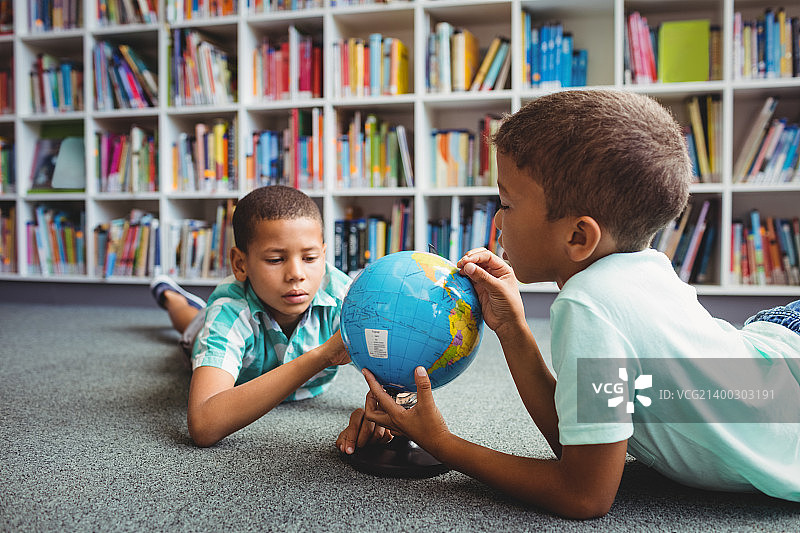 在教室里研究地球仪的男孩们图片素材