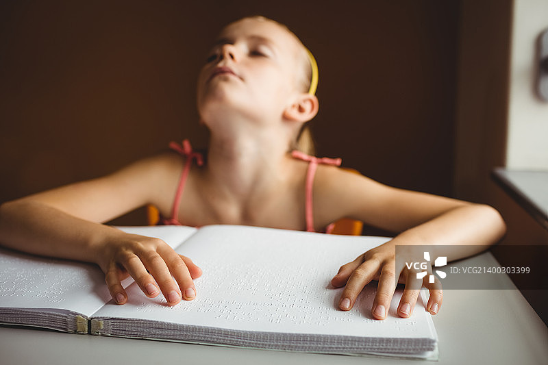 盲人女孩用双手阅读图片素材