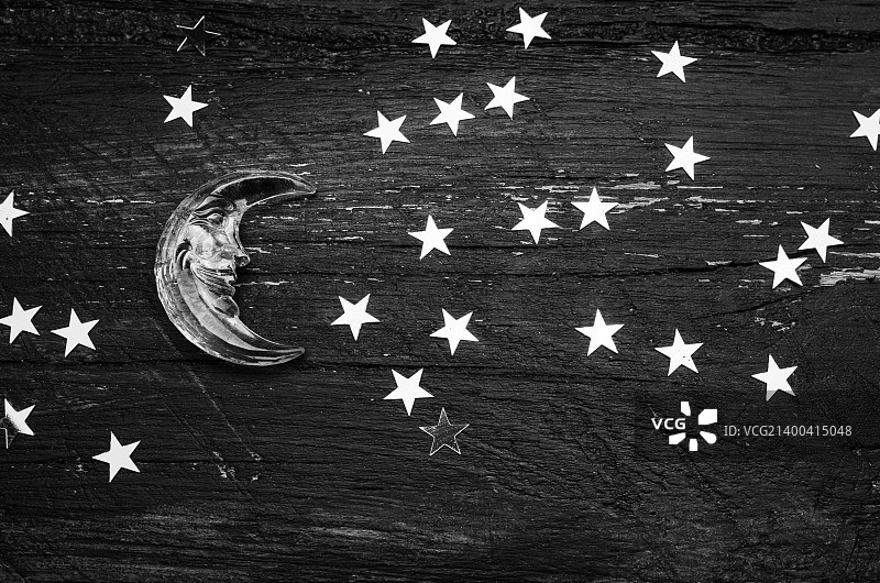 木纹背景上的金色星星和玻璃月亮黑白照片图片素材